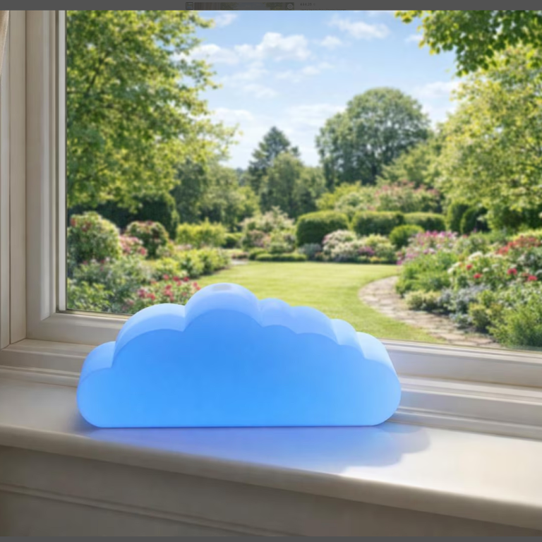 A soft blue cloud-shaped lamp on a windowsill, overlooking a sunny garden.